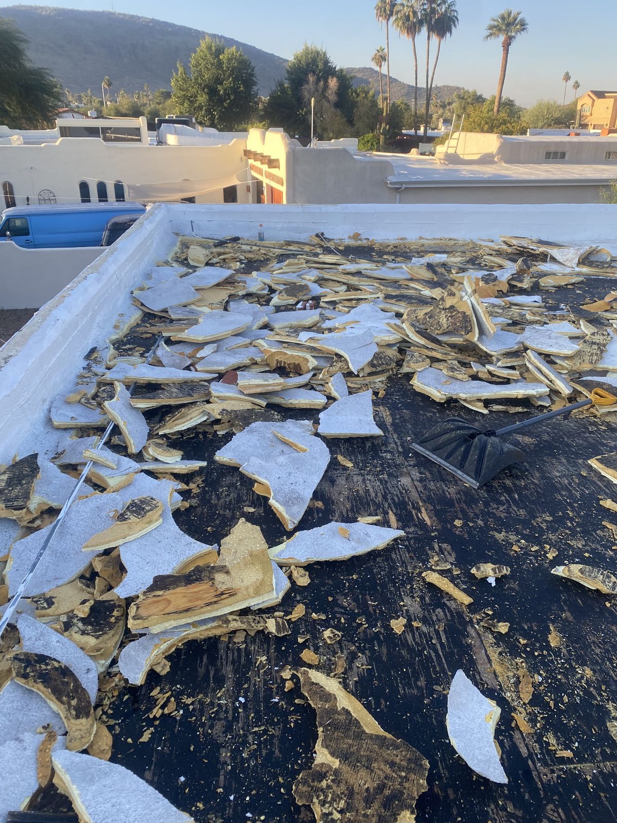 Old flat-roof material being stripped off the deck