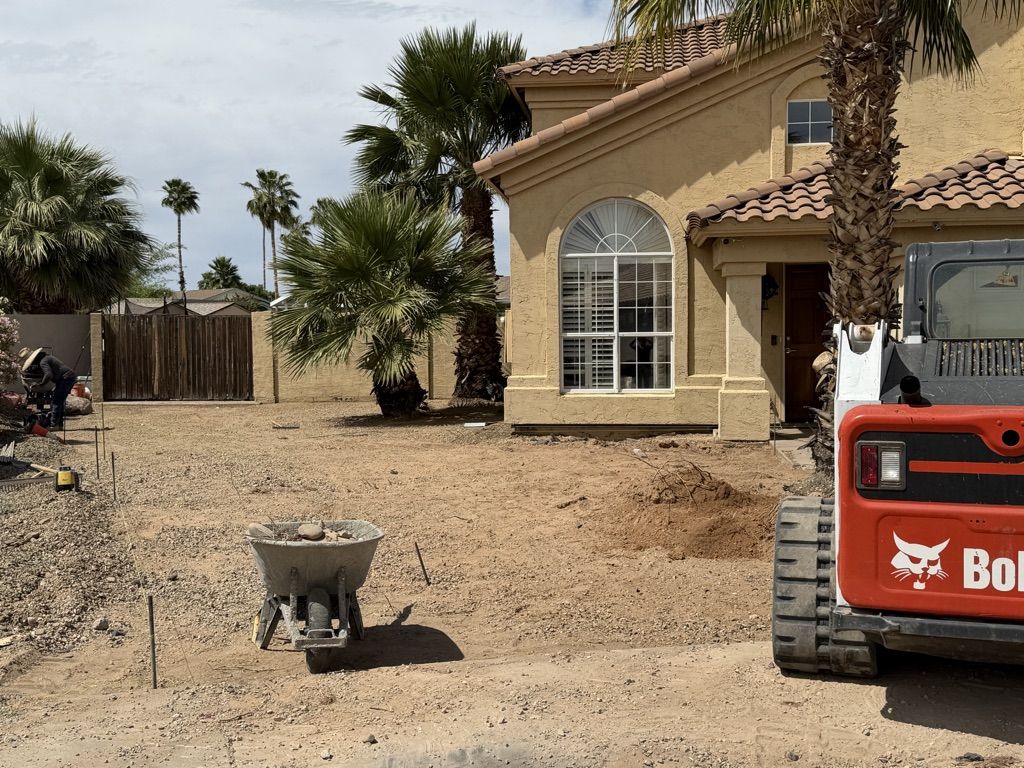 Front yard cleared and graded for new hardscape, compact track loader on site