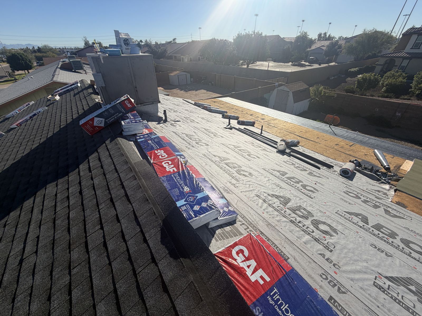 Shingle re-roof in progress, new synthetic underlayment going down over the deck