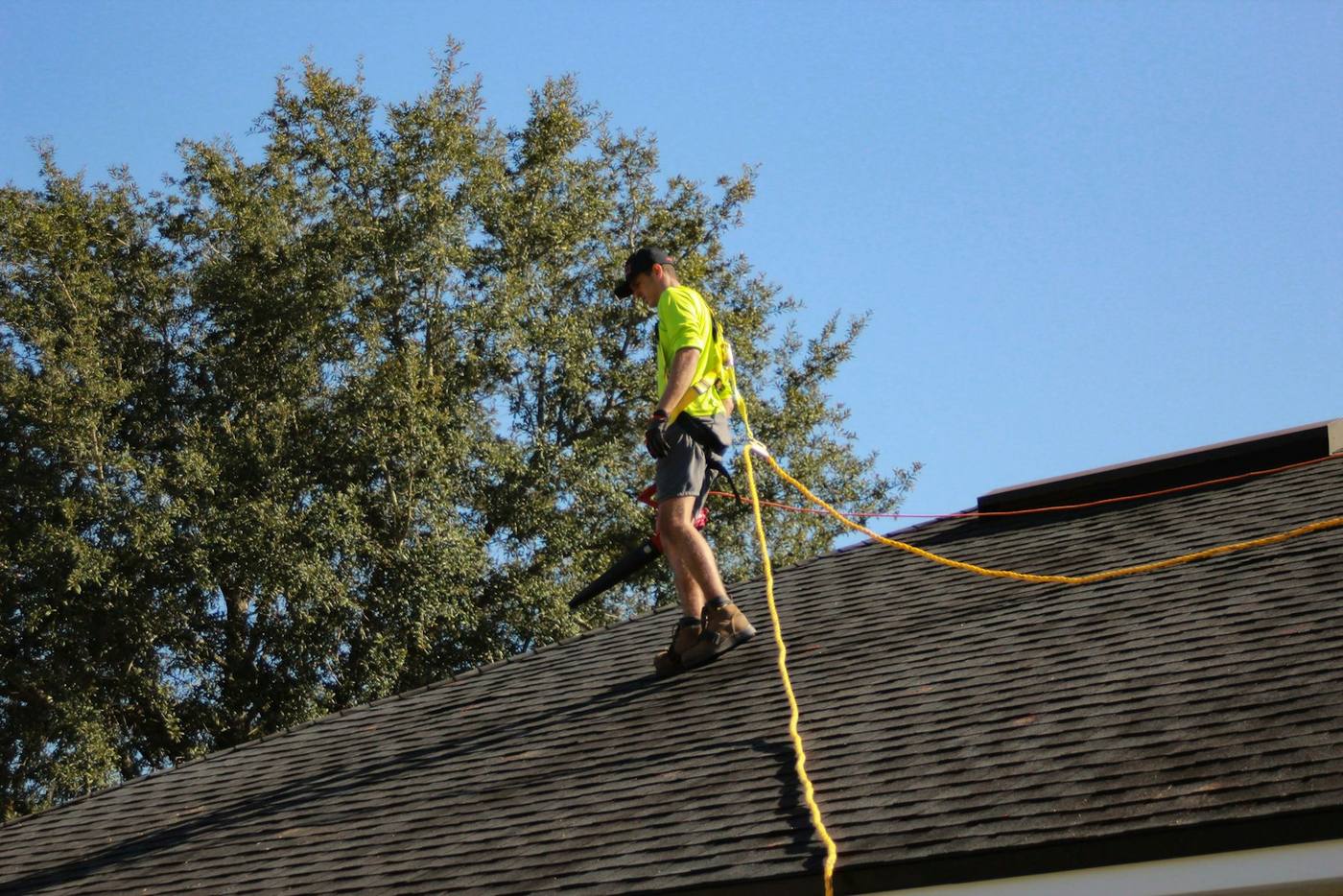 A man on a roof working with a rope