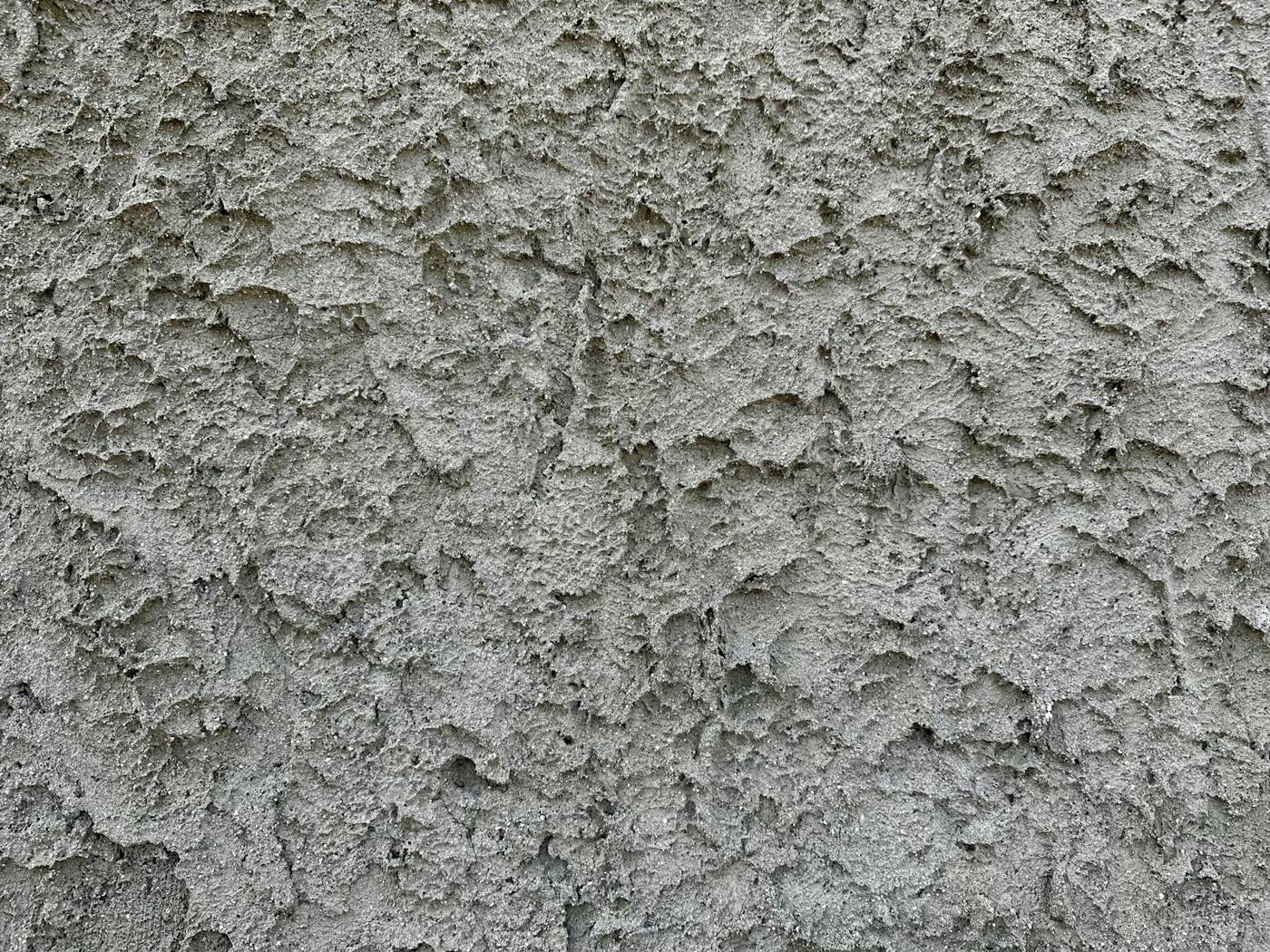 Close-up of textured stucco with fine cracks running through it